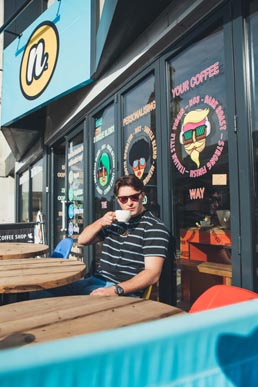 student drinking coffee outside the cafe student drinking coffee outside the cafe