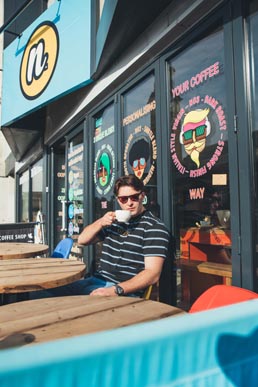 student drinking coffee outside the cafe