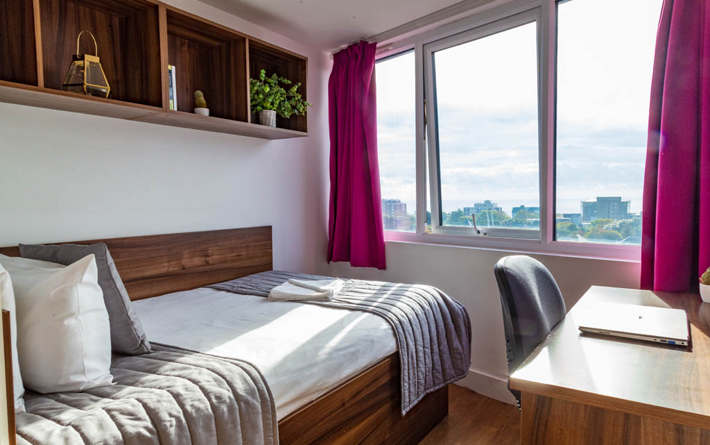 ensuite bedroom with a desk and view of the window