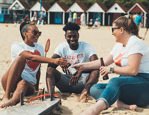 students on bournemouth beach drinking beer